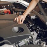 un mecánico accede al sistema de refrigeración del motor de un coche