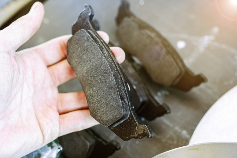 una persona soporta una pastilla de freno sobre su mano