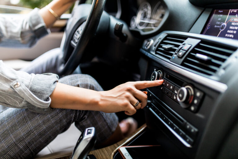 Cómo detectar problemas en el radiador de tu coche y prevenir el sobrecalentamiento 2 car dashboard radio closeup woman sets up radio while driving car