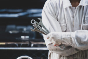 car repairman wearing white uniform standing holding wrench that is essential tool mechanic