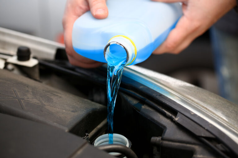 As alterações climáticas e a sua influência na manutenção do nível de água do radiador 12 male hands hold bottle blue antifreeze