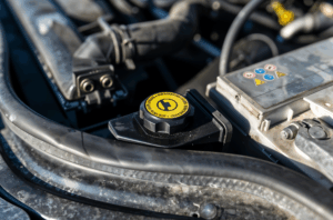 tapon del liquido de direcion ubicado en la parte delantera de un coche entre el resto de componentes
