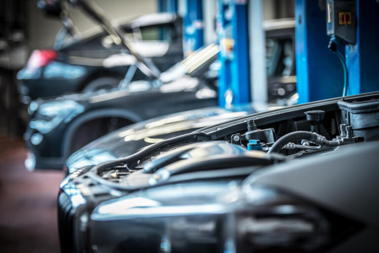 Interior de un taller mecánico en España con coches en reparación, representando la evolución del sector y sus retos actuales.