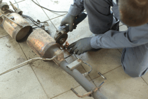 Technicien automobile effectuant un diagnostic du système de protection électrique d’un véhicule avec un multimètre.