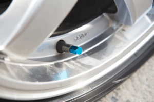 Mécanicien inspectant le joint de queue de soupape d’un moteur automobile pour identifier un problème.