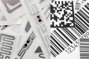 Trabalhador de oficina a utilizar um leitor RFID e etiquetas de código de barras para gerir o inventário de peças automóveis.