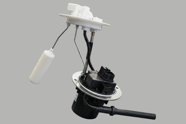 Mecánico revisando un aforador de combustible para diagnosticar y reemplazar el módulo completo del vehículo.