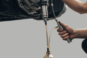 Mecánico reemplazando el cilindro receptor de embrague y purgando el circuito hidráulico en un vehículo.