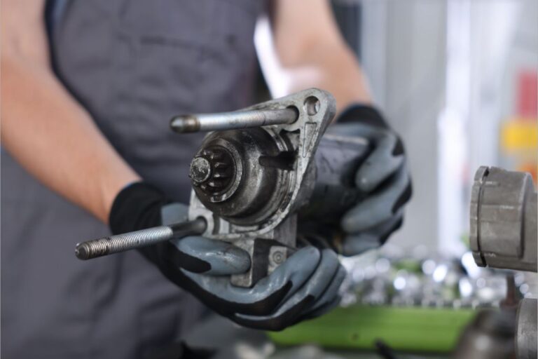 Gestão de stock de motores de arranque: OEM vs. IAM 2 Motores de arranque sobre uma bancada de oficina, comparando peças OEM e IAM para gestão de stock.