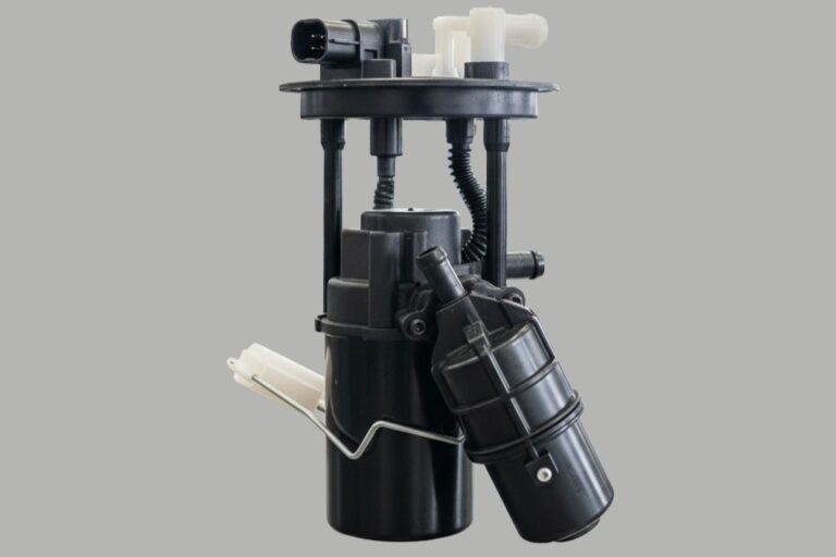 Mecánico diagnosticando la bomba de combustible de un vehículo en un taller profesional.