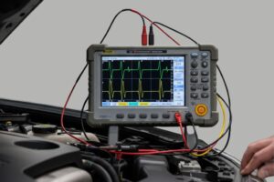 Mecánico usando un osciloscopio automotriz para diagnosticar con precisión sistemas eléctricos y electrónicos del vehículo.