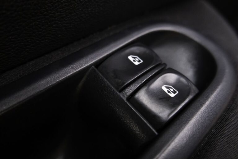 Mecânico a reparar um elevador de vidros num veículo, verificando componentes e realizando diagnóstico.