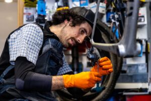 Mecânico a utilizar uma ferramenta elétrica na oficina com equipamento de proteção individual adequado.