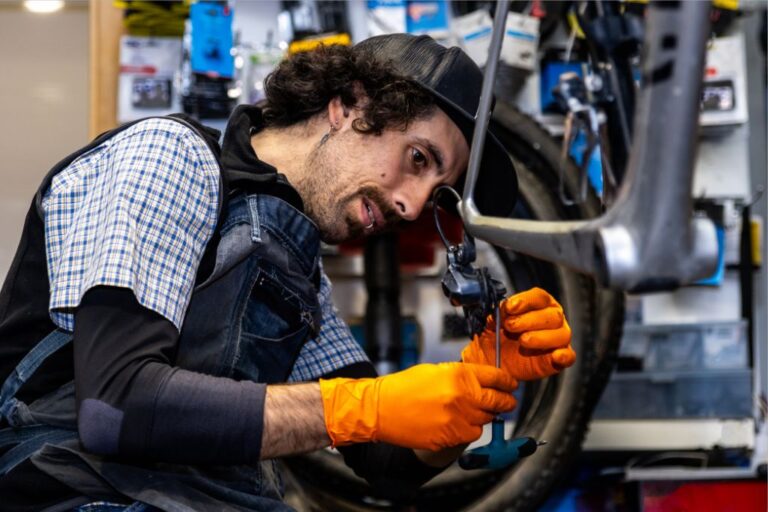 Segurança na oficina: Manuseio seguro de ferramentas elétricas 2 Mecânico a utilizar uma ferramenta elétrica na oficina com equipamento de proteção individual adequado.