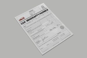 Técnico a usar software num computador para gerir garantias de peças elétricas numa oficina profissional.