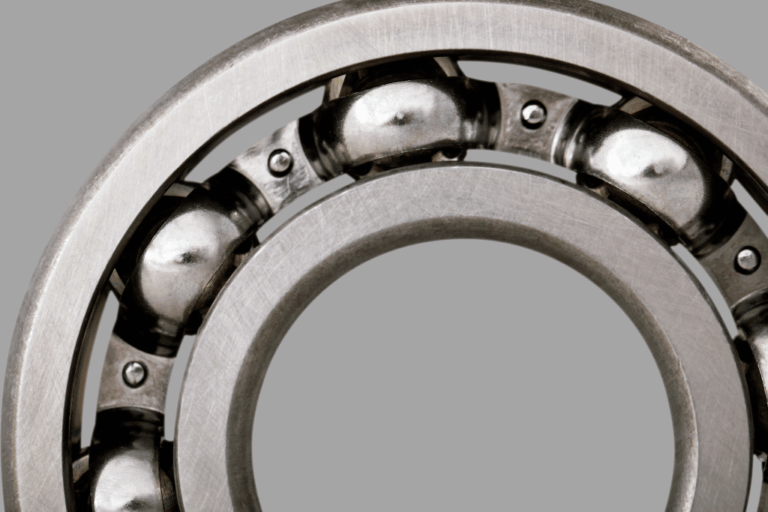 Technicien sélectionnant un palier de roulement adapté à un arbre de transmission en atelier.