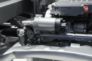 Mécanicien vérifiant une crémaillère de direction sur un véhicule pour détecter une fuite ou un jeu excessif.