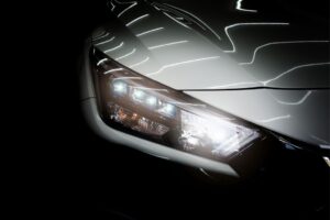 Mecánico gestionando recambios de faros LED y xenón mediante un catálogo digital en el taller.