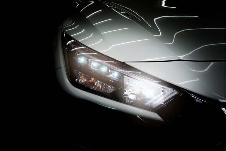 Mecánico gestionando recambios de faros LED y xenón mediante un catálogo digital en el taller.