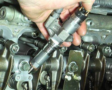 Extractor de Inyectores Neumático: Cómo Afrontar la Reparación Más Temida 2 Mecánico utilizando un extractor de inyectores neumático para retirar un inyector del motor.