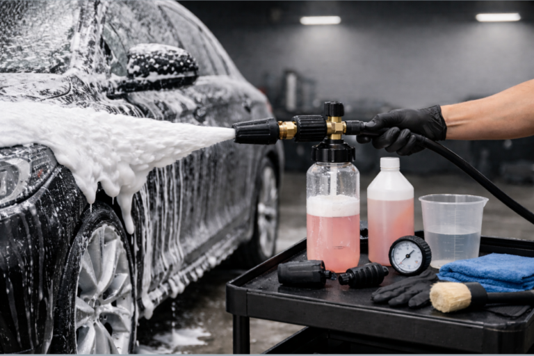 Canon à mousse professionnel appliquant une mousse dense sur la carrosserie d’un véhicule en atelier.