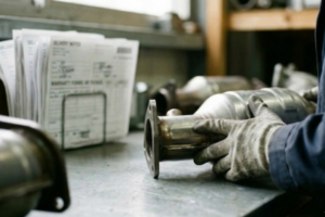 Profissional a gerir processos de garantia de peças entre empresas, com documentação e controlo técnico num contexto B2B.