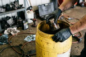 Profissional a gerir resíduos de oficina de forma organizada e segura, em conformidade com os procedimentos legais aplicáveis.