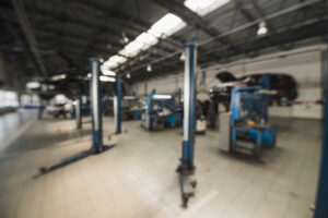 Réception de garage avec poste d’accueil organisé, ordinateur flou et agenda de planning sans texte lisible, suggérant la prise de rendez-vous en ligne.