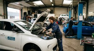 Mains de mécanicien avec gants isolants sur système électrique