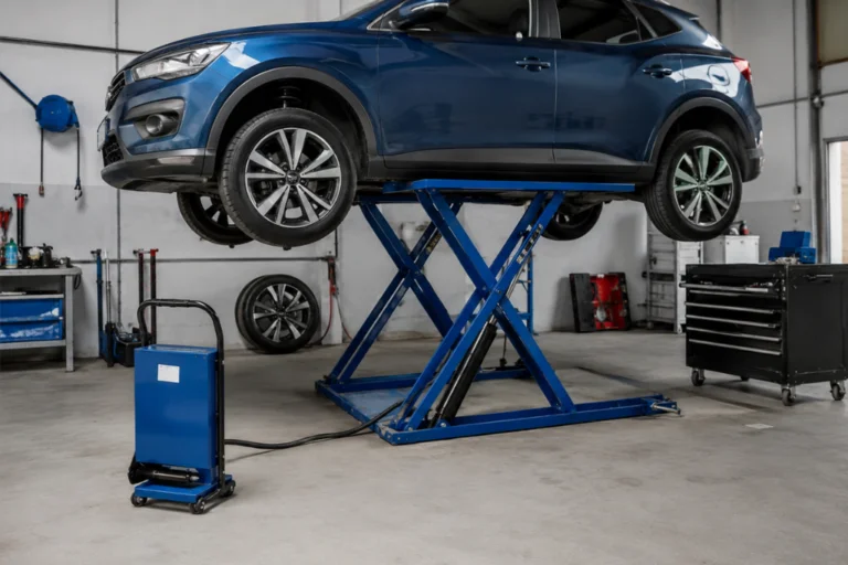 Elevador de coche portátil para taller: tipos, precios y lo que debes saber antes de comprar 1 Coche azul suspendido en un elevador de tijera hidráulico de color azul dentro de un taller mecánico.