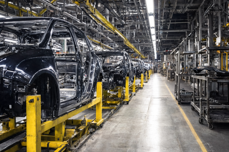 Chasis y carrocerías de vehículos negros en la línea de montaje automatizada de una fábrica de automóviles.