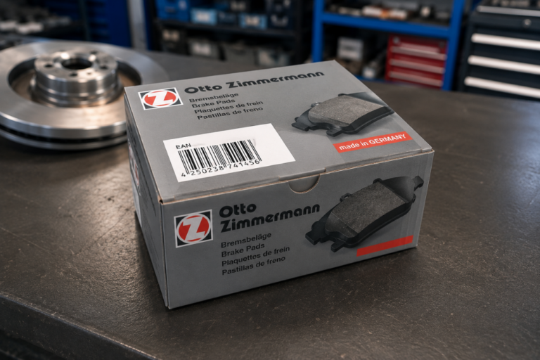 Caja de pastillas de freno marca Otto Zimmermann en un banco de trabajo de taller con un disco de freno al fondo.