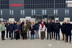 Grupo de empleados y profesionales posando en el exterior de las instalaciones logísticas de Autocirc