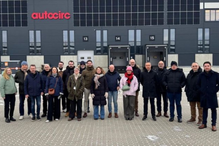 Grupo de empleados y profesionales posando en el exterior de las instalaciones logísticas de Autocirc