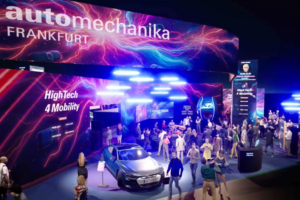 Stand de exposição na feira Automechanika Frankfurt com carro de alta tecnologia e visitantes no evento.