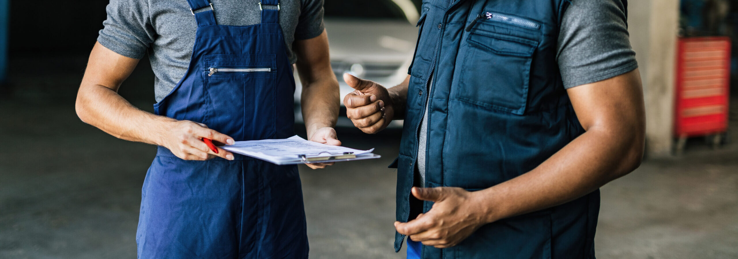 african-american-car-mechanic-his-coworker-communicating-auto-repair-shop-scaled-e1790249970202.jpg