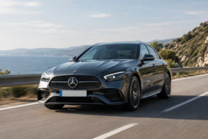 Mercedes-Benz Clase C de color gris oscuro circulando por una carretera junto al mar.